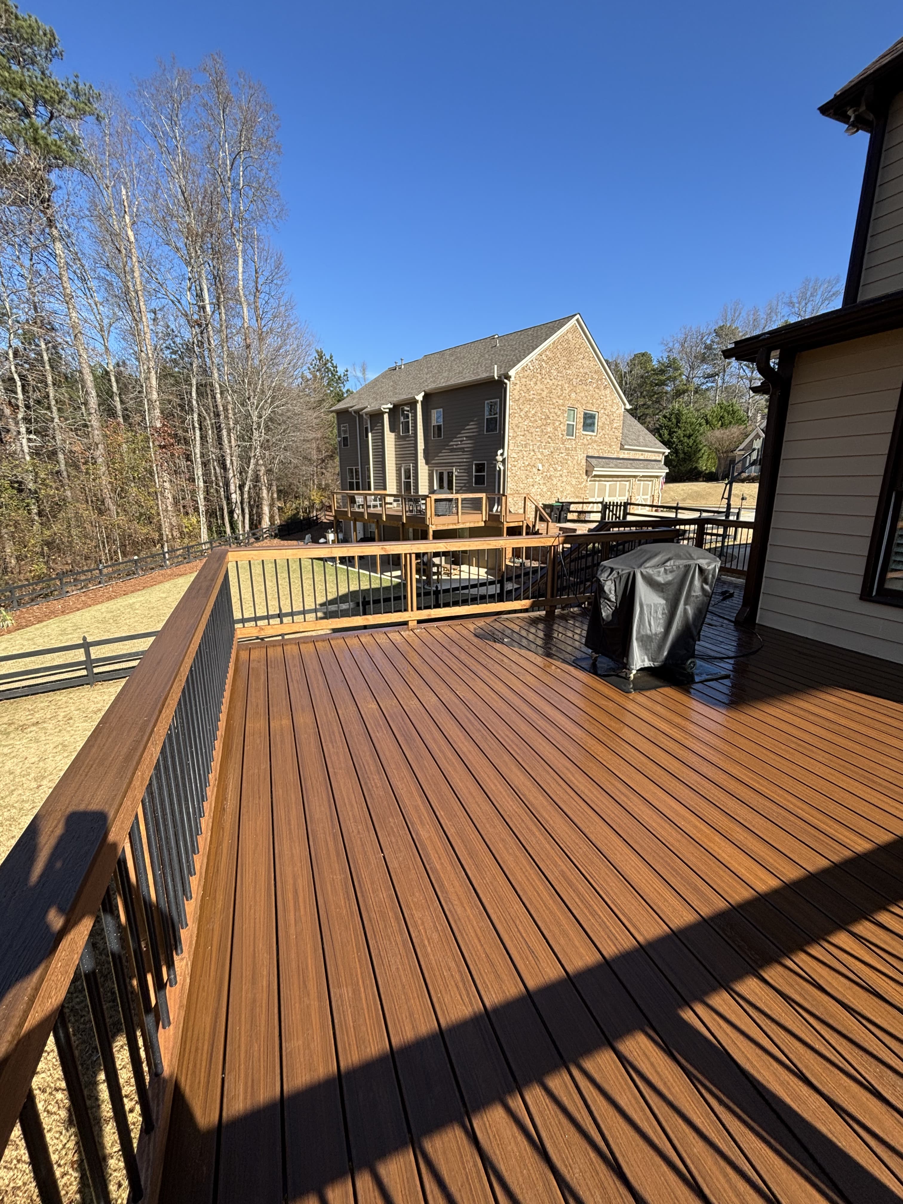 Large walnut-brown composite deck with metal balusters