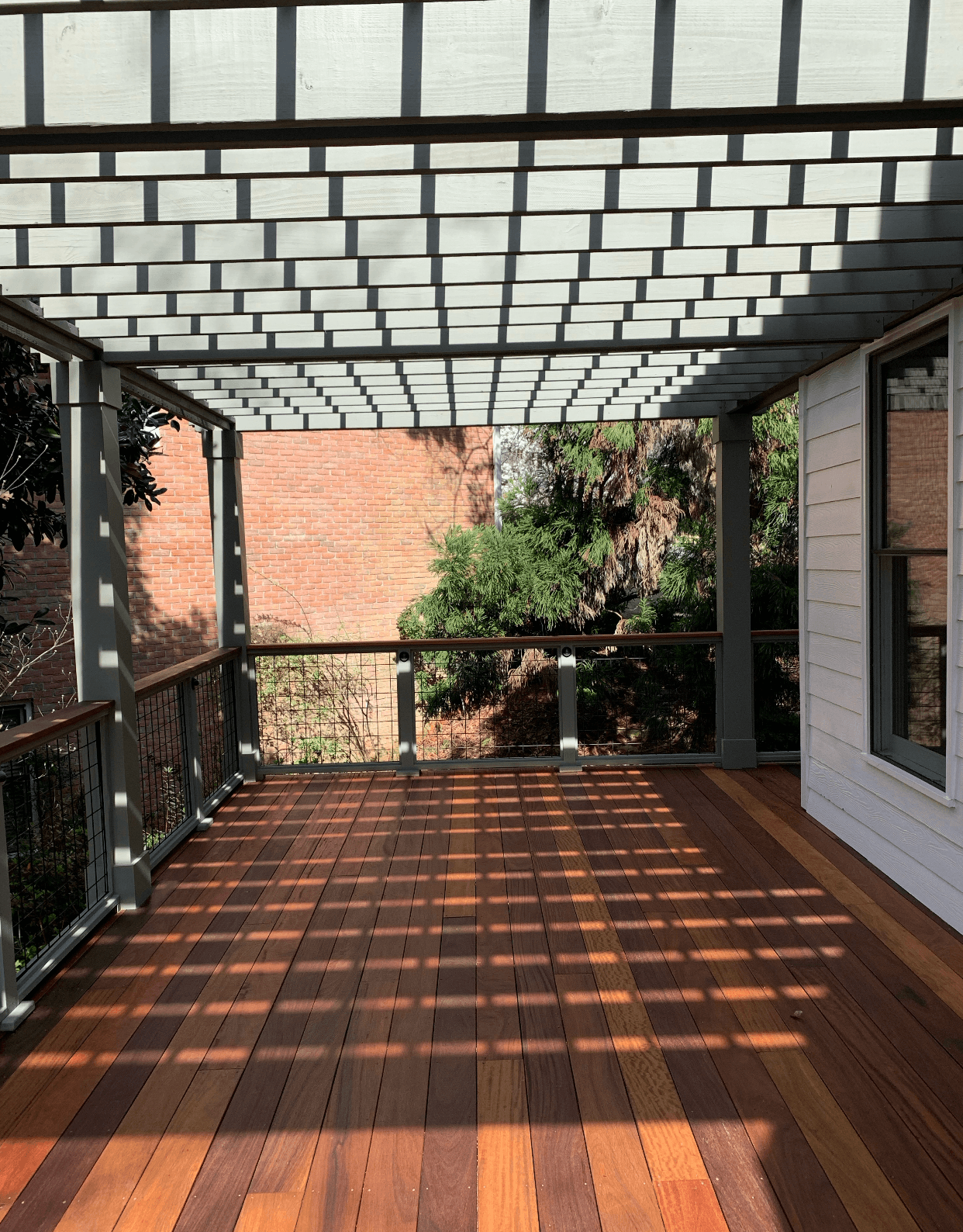 Ipe deck with pergola shadow patterns and modern railings