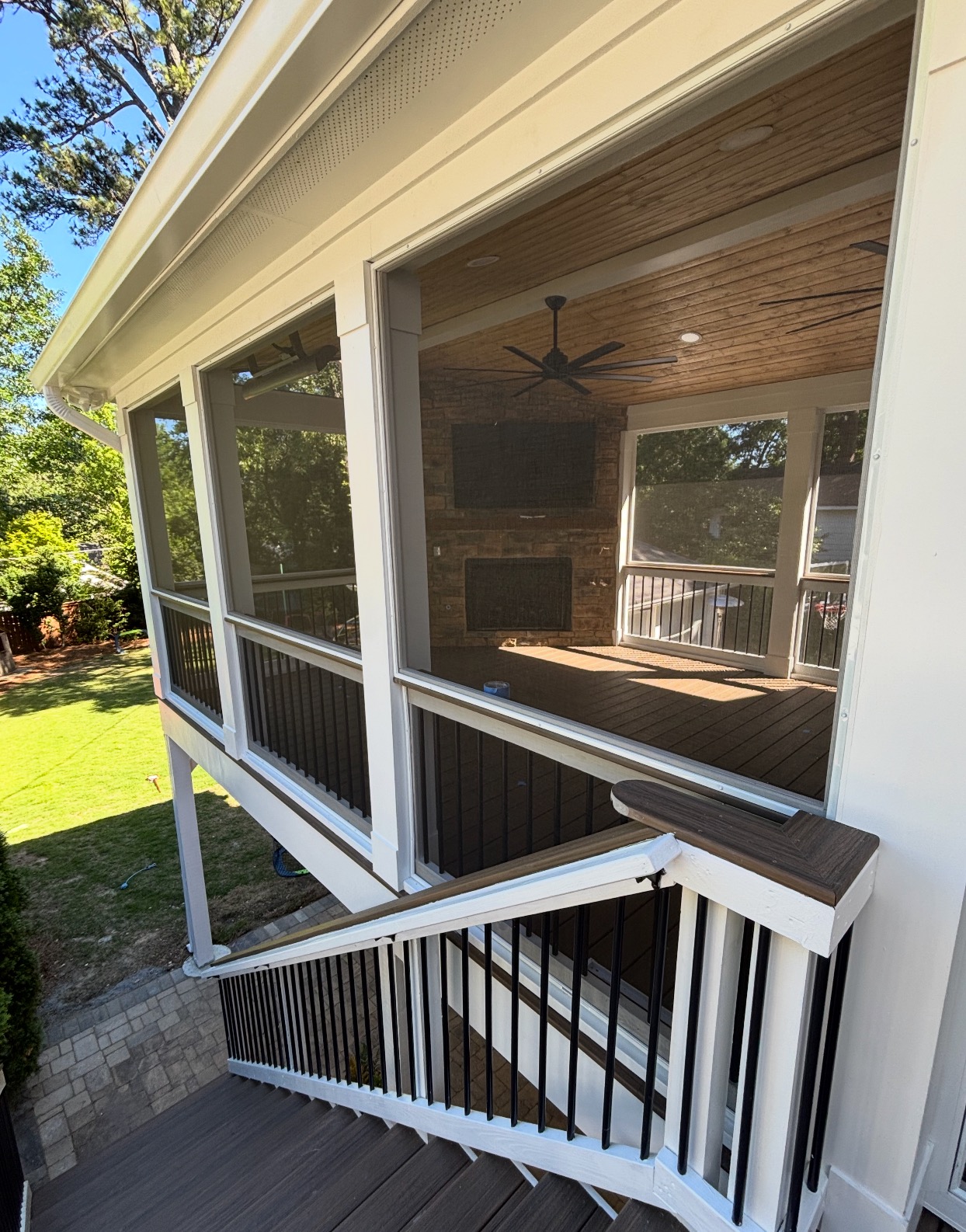 Exterior view of screened porch with white trim and composite railings