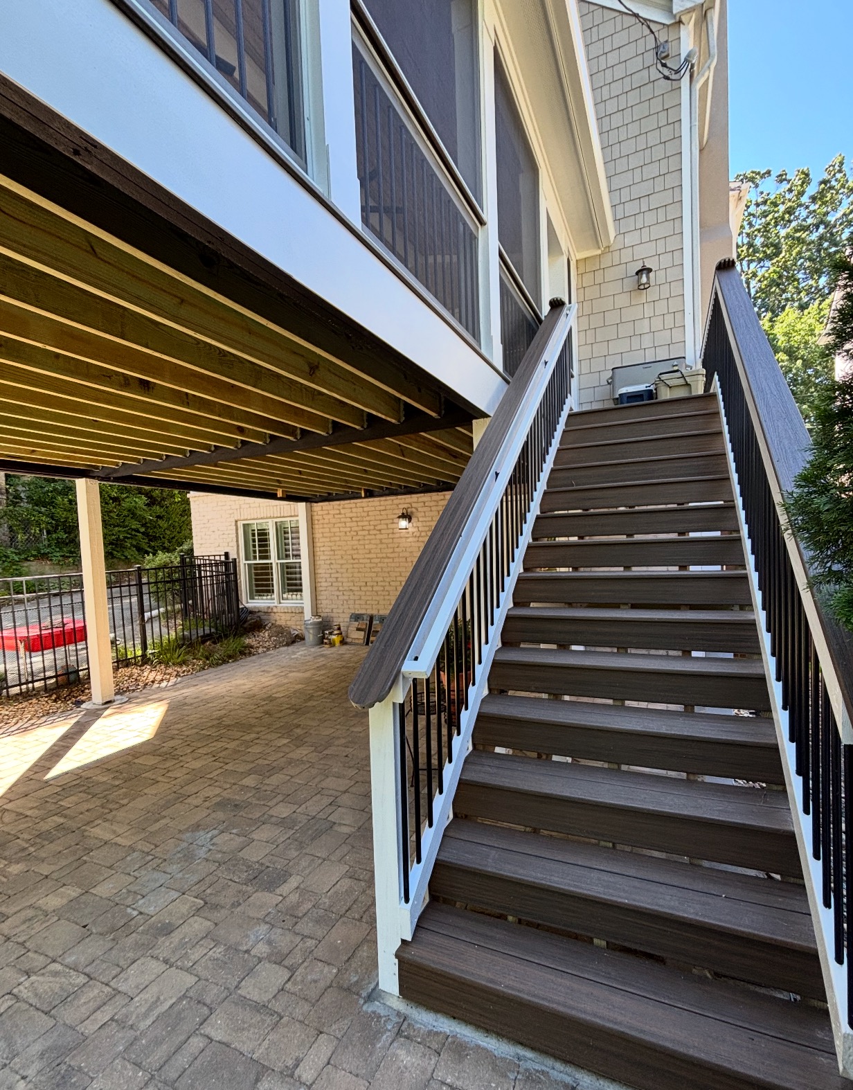 Composite deck stairs with under-deck drainage system