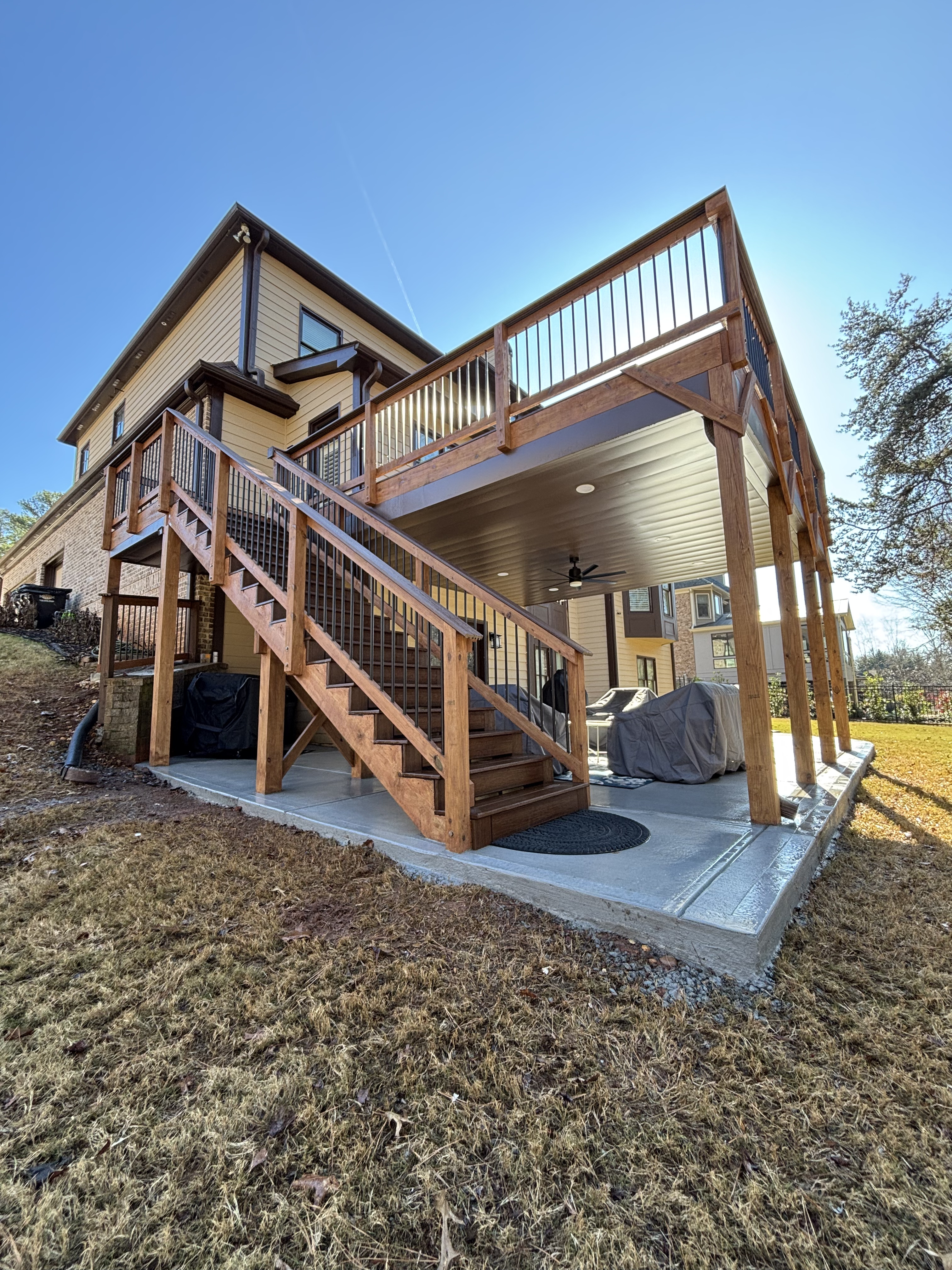 Two-story stained wood deck with covered patio