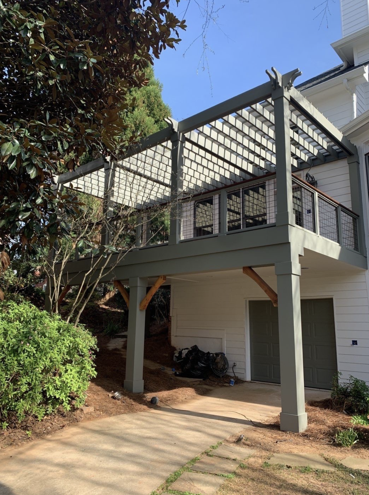 Elevated deck with white painted pergola and cedar braces