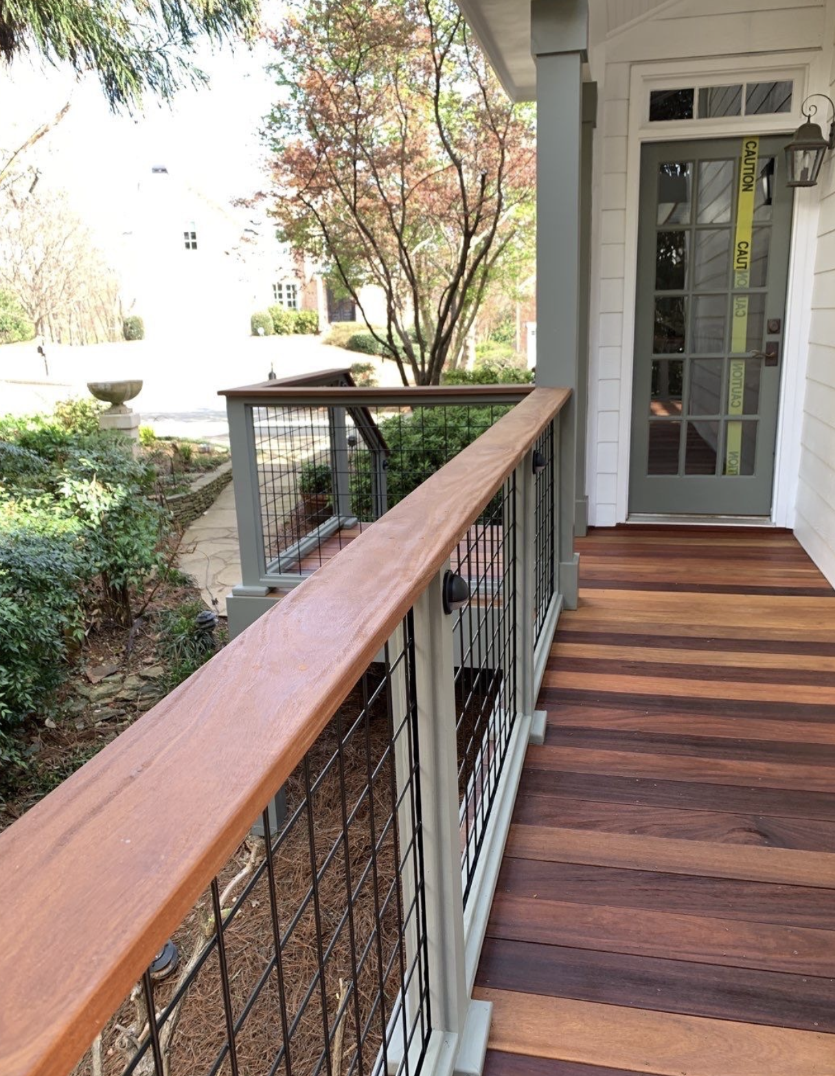 Hardwood deck with sage green posts and mesh panel railings