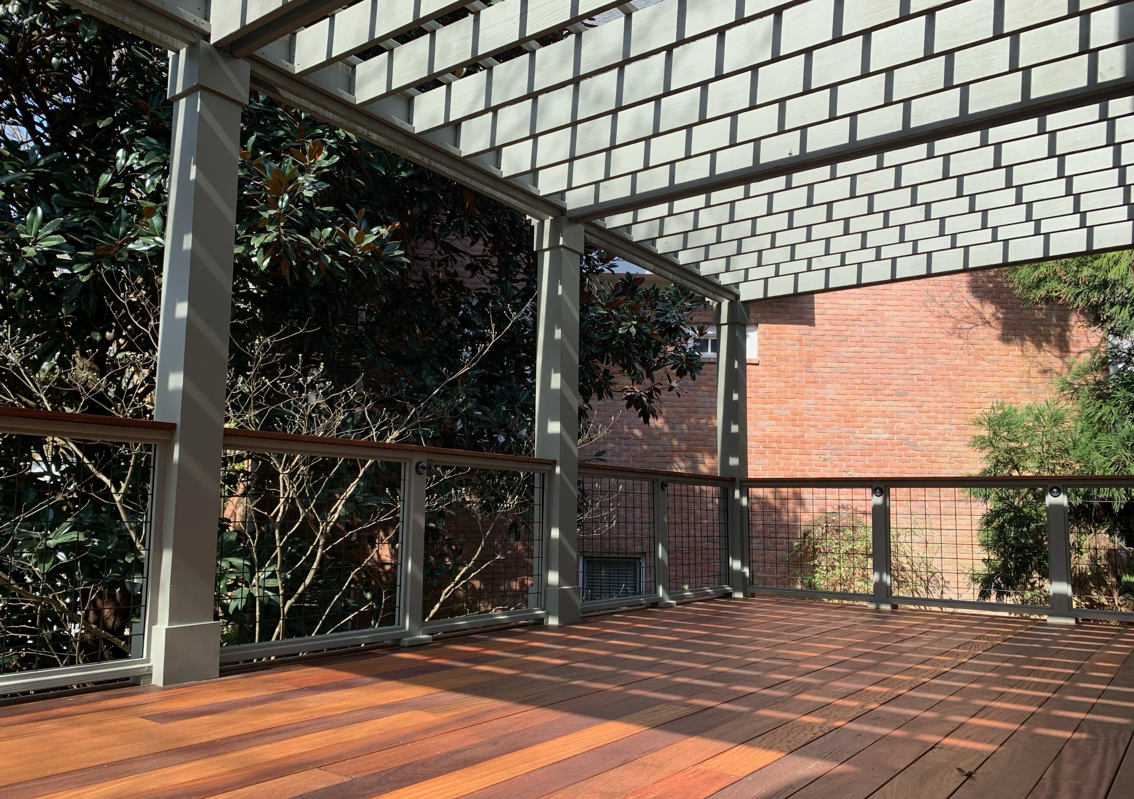 Ipe hardwood deck with white pergola and cable railings