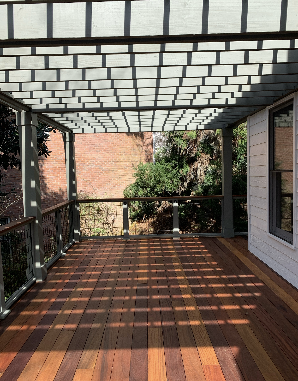 Ipe deck with pergola shadow patterns and modern railings