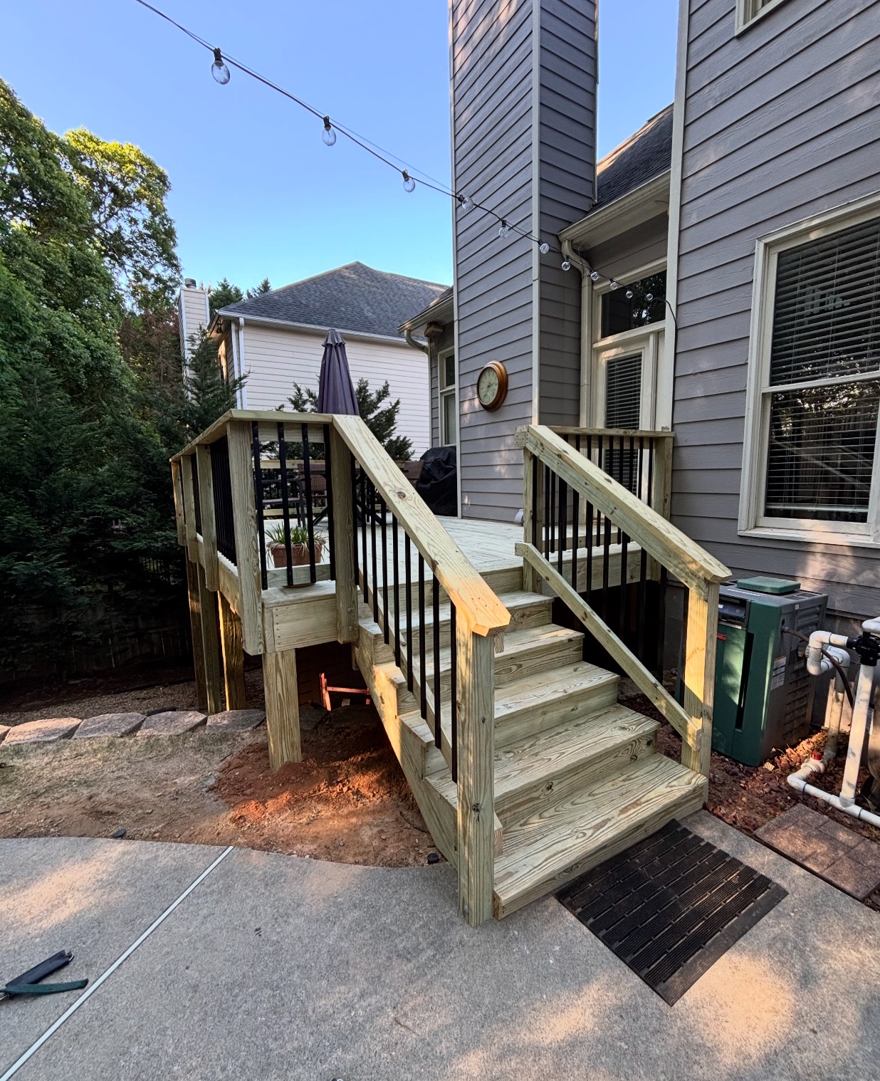 Pressure-treated deck with stairs and black metal balusters