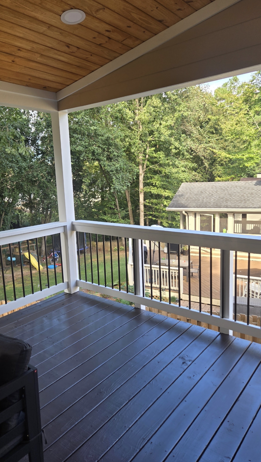 Covered porch with cedar ceiling and white railings