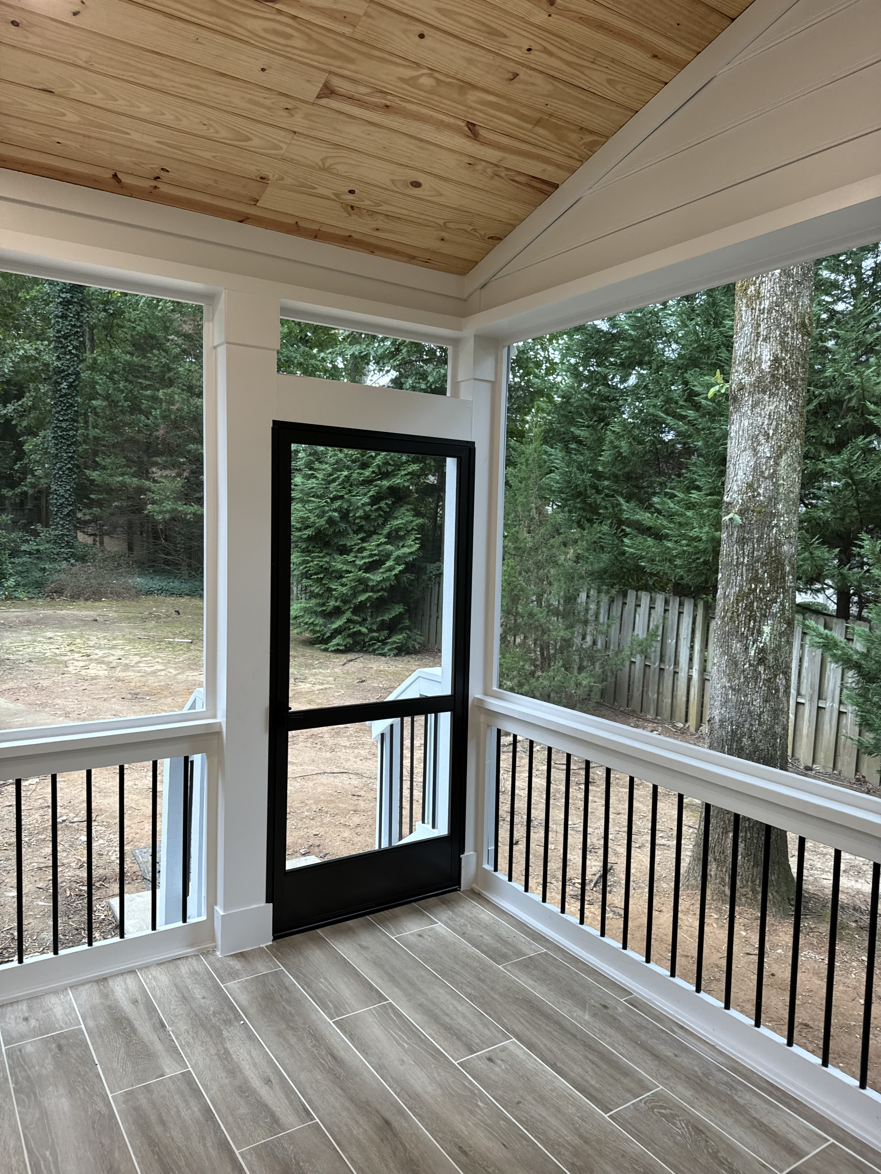 Screened porch with natural pine ceiling and wood-look tile